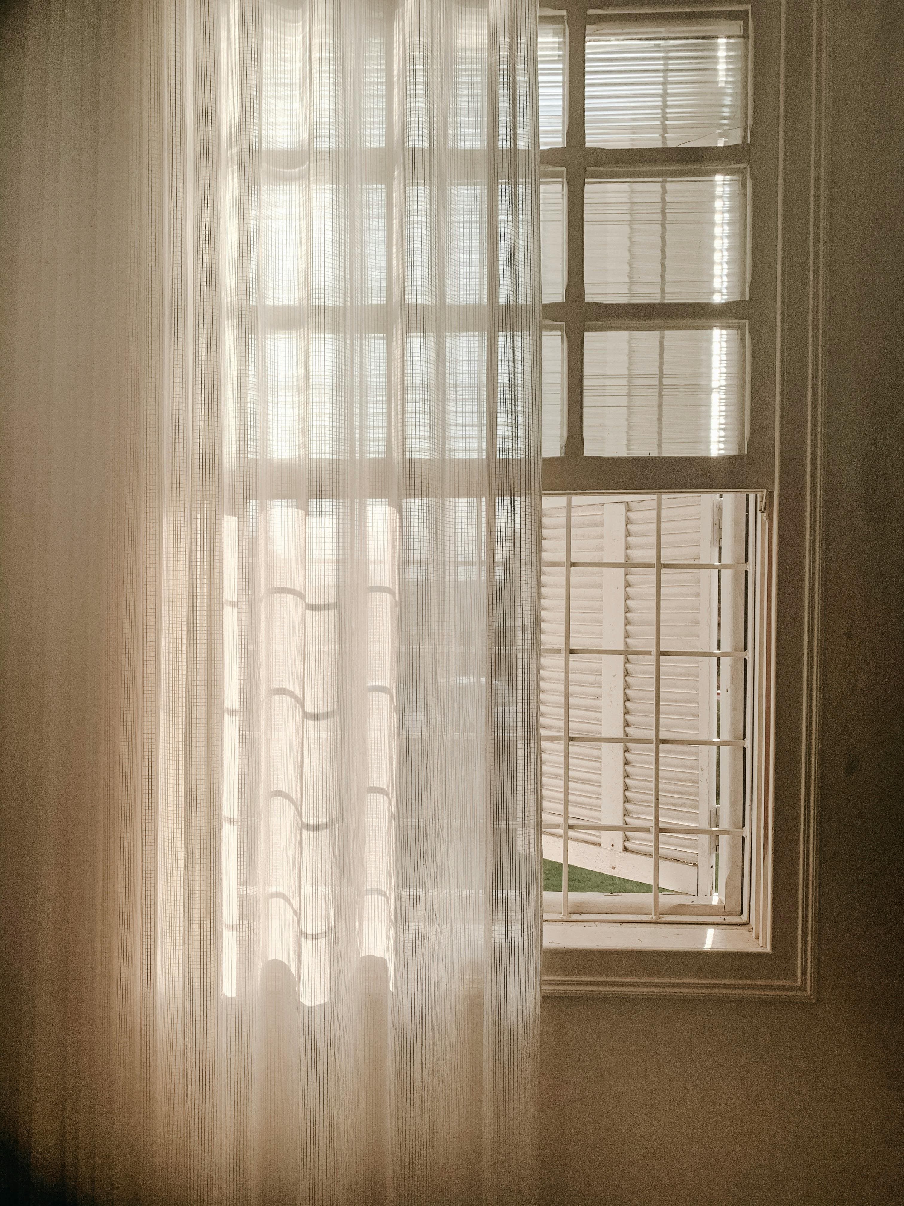 Curtain rod mounted above a window with draped fabric
